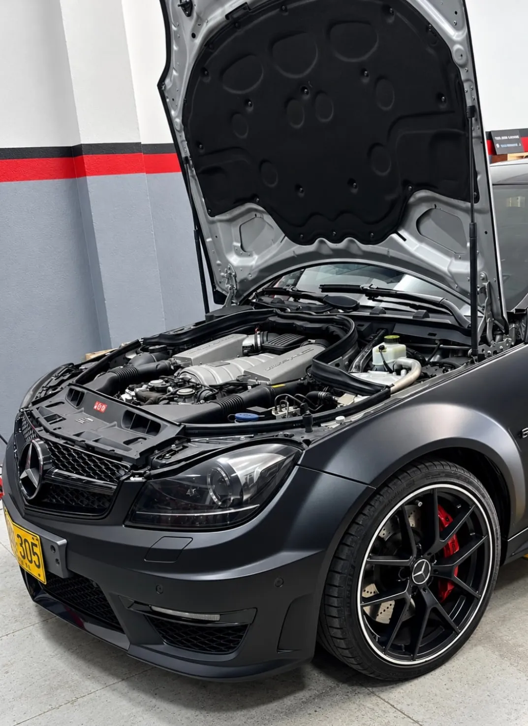 Mercedes-Benz AMG con el capó abierto en el taller de Precision Garage